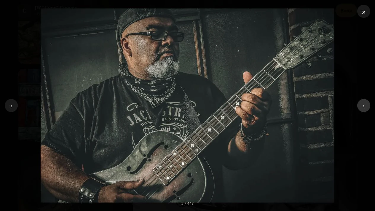 JW Cooper Photography: Musician wearing glasses and a cap playing a resonator guitar